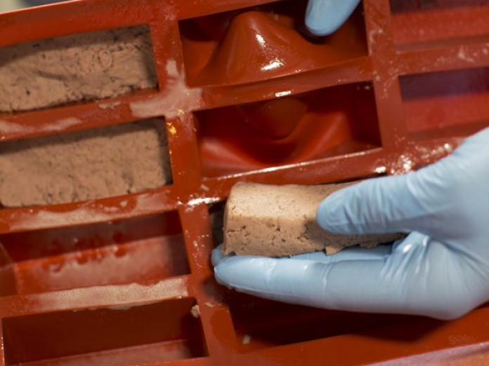 Gratineret kød, der tages ud af en silikoneform.